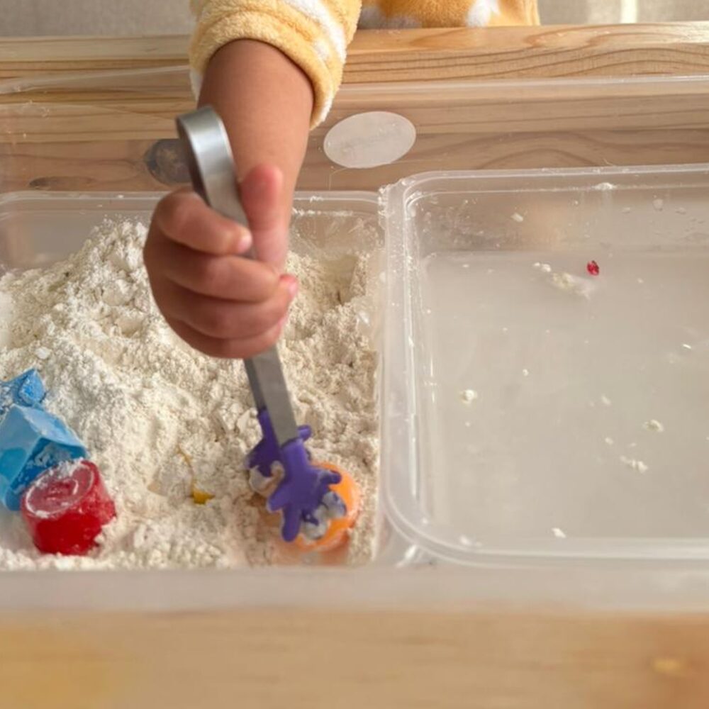 Flour and water sensory bin with tongs