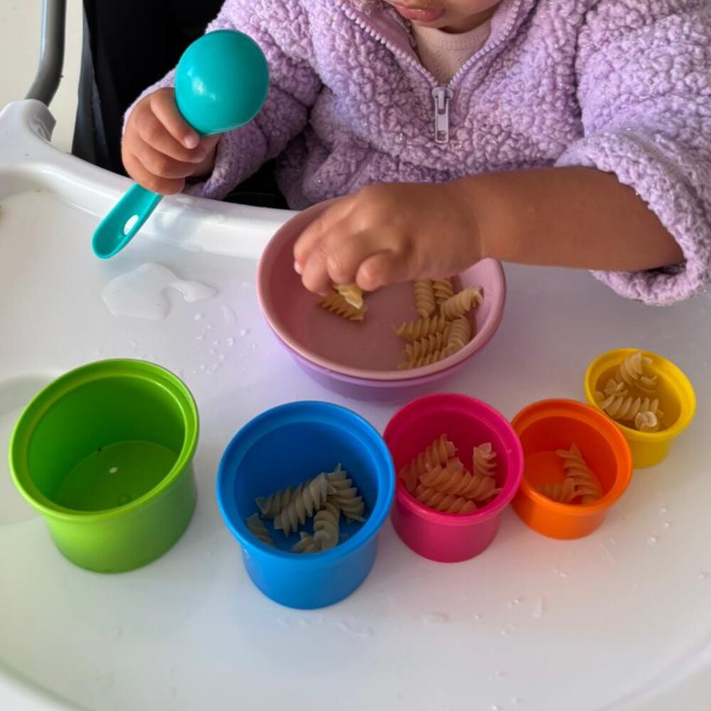 Spooning pasta into colour-coded cups